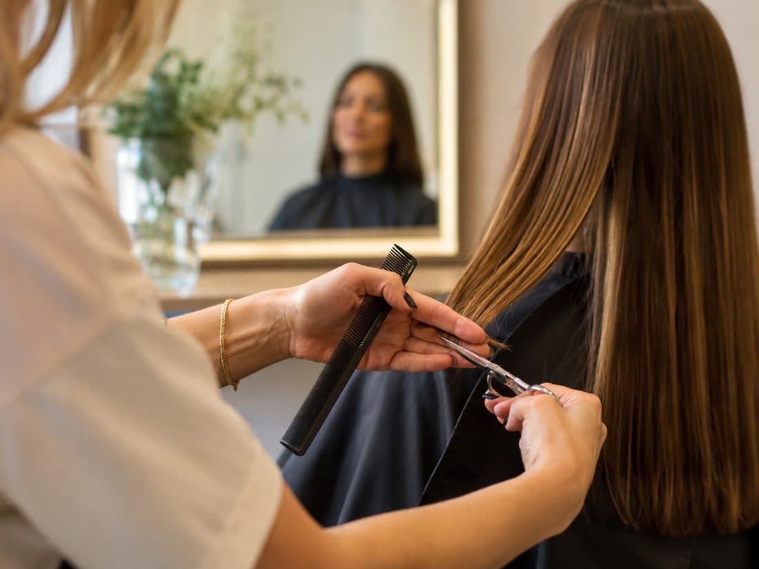 Cabeleireira cortando o cabelo de uma cliente com a tesoura
